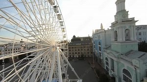 FPV drone footage. Fly over Kontraktova Square at Kyiv near ferris wheel. Ukraine, Kyiv - 10 august 2021.
