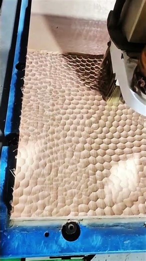 CNC cutter carving honeycomb pattern into wood