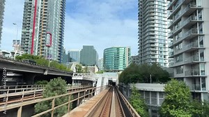 blue line skytrain front the whole process with people on the train railroad view trees summer train view big city life BC, Vancouver, Canada