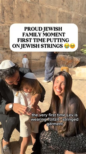 Raizel and Daniel Namdar on Instagram‎: "Levs first time wearing Tzitzit on his 3rd birthday, from here on he wears it every day and night like his father and older brother ❤️ This is an emotional moment for us as parents as we reach a new milestone thank G-d in parenting with Lev 🥹 Tzitzit are the strings attached to the four corners of a Jewish garment and are worn to help us “remember all the commandments.” The word “Tzitzit” (ציצית) in Hebrew has a numerical value (gematria) of 600- Add the