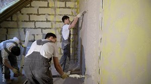 Plastering mortar machine. Automatic plaster. Repairing or renovating house or apartment. Builder at construction professional