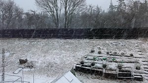 Beautiful view of spring gardens behind the villas during a spring snowfall. Sweden. Stock Video