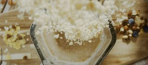 Adding protein powder into the milkshake in the modern blender. Making a nutritious smoothie for breakfast