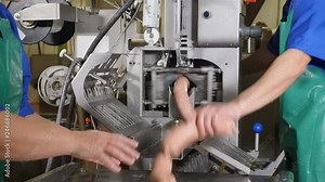 Slaughtering and meat-processing plant. Female hands operating sausage production line. final part of sausage conveor in meat factory. 4k