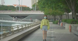 Asian Chinese girl wearing a surgical face mask to protect herself from COVID-19 coronavirus infection in crowded public places
