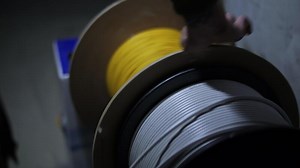 Worker unwinding reel with internet cable