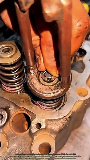 Un mécanicien expert installe des clavettes de soupape sur une culasse.