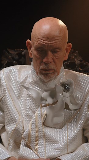 It’s time to meet your President. John Malkovich wears the rose in The Hunger Games On Stage. A towering on-screen performance, brought to life inside Troubadour Canary Wharf with cutting-edge theatre technology. | The Hunger Games On Stage