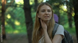 Lady suffers from mosquitoes bite while camping, killing bug with hand, itching