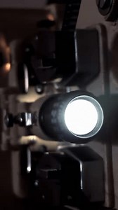 Old Film Projector in Action in a Dark Cinema Projection Booth. Close Up.