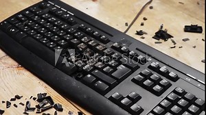 Shattered desktop keyboard. Lockdown. A fired worker smashes a computer keyboard with a hammer. Broken office equipment. The losing computer player breaks the keyboard. Depression at work.