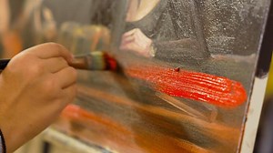 Artistic process of painting a detailed portrait in a studio setting