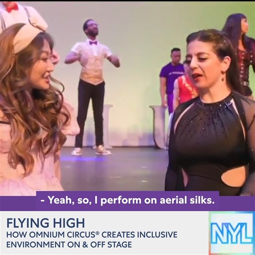 Michelle Park recently visited the New Victory Theater to speak with the company of Omnium: A Bold New Circus! #NVImPossible ACCESSIBILITY: Michelle Park, in a pink dress and pink headband with a bow, stands in front of the New Victory stage with Lisa Lewis, in all black. On the stage in the background, the diverse company of Omnium performers warm-up and practice tricks in their show costumes. It cuts to a show of the New Victory house and dome, before cutting back to Michelle and Lisa. It cuts