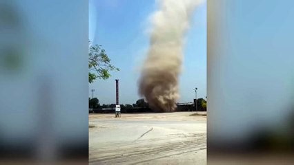 A dust devil surprises workers at a factory in Suphanburi, Thailand