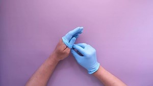 man doctor wears medical gloves, close up