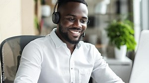 Smiling customer service agent wearing a headset in a professional office environment.