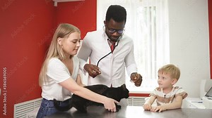 Vet and owners calm down frightened cat in clinic before medical examination.