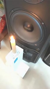 点燃的蜡烛放在音响前，音响也想低调，但是蜡烛不允许啊