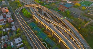 Numerous motorways crossing each other and intertwining. Tennis courts located between the roads. Top view.