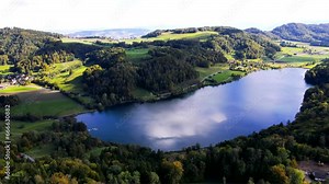 panoramic aerial view of beautiful alpine lake in the swiss alps featuring rural landscapes and green sceneries in switzerland
