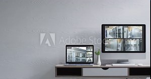 Wall mounted computer monitor and laptop on desk with security camera views on screens, slow motion