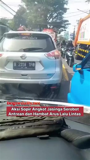 Aksi sopir angkutan kota (angkot) jurusan Jasinga, Kabupaten Bogor menyerobot antrean kendaraan di jalan raya. Dalam rekaman tersebut, sopir angkot terlihat mengambil jalur dari sisi kanan jalan untuk mendahului antrean kendaraan. Tindakan itu menyebabkan kedua arus lalu lintas terhambat dan memicu kemacetan di lokasi kejadian. Source: dashcam_owners_indonesia #bogordailynews #angkot #viral