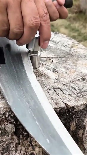 testing a sharp steel blade edge using a small metal cylinder for professional tool quality control