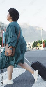 Vertical video of happy plus size biracial woman walking on street with luggage