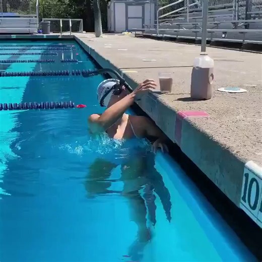 La nadadora Katie Ledecky, 7 veces medallista de oro olímpica, equilibra un vaso de leche con chocolate sobre su cabeza mientras nada