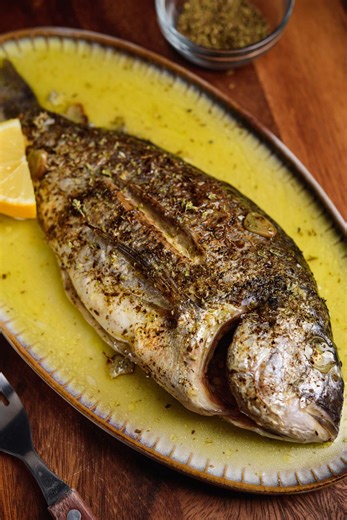 Here's an easy way to cook a juicy and delicious Sea Bream at home. Baked wrapped in parchment with extra virgin olive oil, garlic, oregano, and lemon. Full recipe here: https://realgreekrecipes.com/greek-oven-baked-sea-bream-recipe/ | Real Greek Recipes