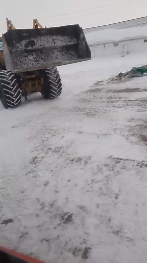 Front Loader Dumping Gravel on Snowy Ground