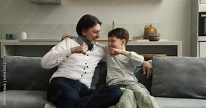 Daddy always support me. Bonding single father preteen son hug on sofa talk bump fists express friendship unity. Laughing divorced dad teen boy best friends make fist bumping gesture mean partnership