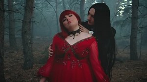 Gothic man vampire in black tailcoat hugs touches bites kisses neck drinks blood of woman pale skin red lips. Happy lady fantasy couple two evil face. Red dress. Blue mystery fog forest dark old tree
