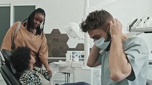 Dentist Putting on Mask and Gloves
