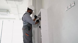 African american plumber installing fire hydrant in office. Fire protection systems maintenance for safety