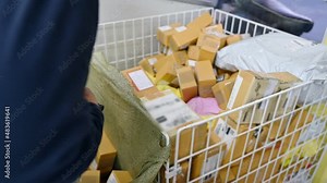 Delivery man scanning cardboard parcel from distribution center