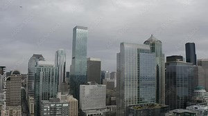 Revealing panoramic view of downtown Seattle, Washington USA with Puget Sound harbor and pier and plane flying over - 4K Drone