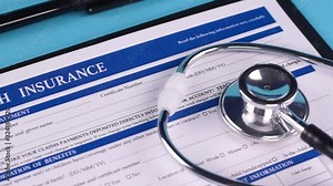 Health insurance form, stethoscope and pen on a blue background. Close-up