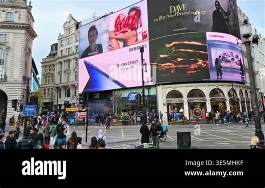 London, UK - October 25, 2025: A bustling scene at Piccadilly Circus, with a lively crowd of people crossing the busy intersection. The streets are filled with traffic, including numerous cars and iconic red double-decker buses zipping by Stock Video Footage - Alamy