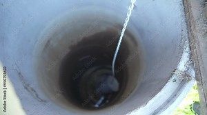 Fetching water from well by hand, fresh pure drinking mineral water.