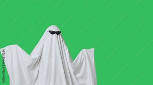 Funny halloween ghost in white sheet wears black glasses dancing coolly, isolated on chroma key green screen background. Happy halloween spooky concept. Stock Video