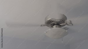 Gray beautiful contemporary ceiling fan in house spins fast tilt up