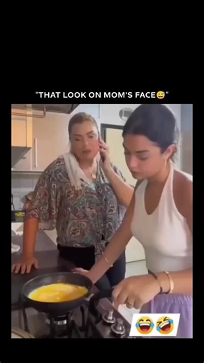 Navneet kaur on Instagram: "The video shows a young woman in a kitchen attempting to cook or flip scrambled eggs or an omelet in a frying pan, but doing it awkwardly and spilling the food. Her mother, who is on the phone nearby, reacts with visible shock and frustration, using expressive hand gestures and appearing to complain about the situation to the person on the call. Laughing emojis are overlaid on the clip to emphasize the humor. The dialogue is in Portuguese, and the on-screen subtitle r
