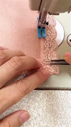 sewing the peach lace fabric precisely using a metal power sewing machine tool in a workshop area