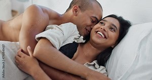 Happy couple, hug in bed and love with cuddle and romance at home for relationship, smile and bonding. Young people, woman and man relax in bedroom, intimacy and laughing with kiss and talk together