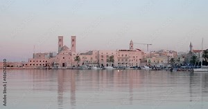 Panoramic view 4K video of Molfetta waterfront with the Old Cathedral San Corrado (Duomo Vecchio),port with ships and yachtsand the Molfetta city sunset. Apulia ,Italy
