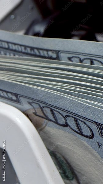 Vertical video.Money counting equipment for paper money calculation. Automatic mechanism for bank financial operations. Currency exchange of one hundred usd. Closeup currency counting machine counting