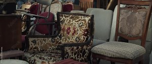 Retro old-fashioned furniture for sale on a flea marketplace outdoors. Slow motion.