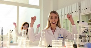 Team of happy scientists celebrating success in laboratory