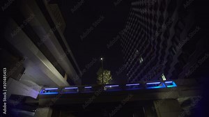 Futuristic bridge geometric Modern building Blue architecture at night with neon light spots at business district in Paris, slow movement low angle in fish eye, Tracking out under bridge.